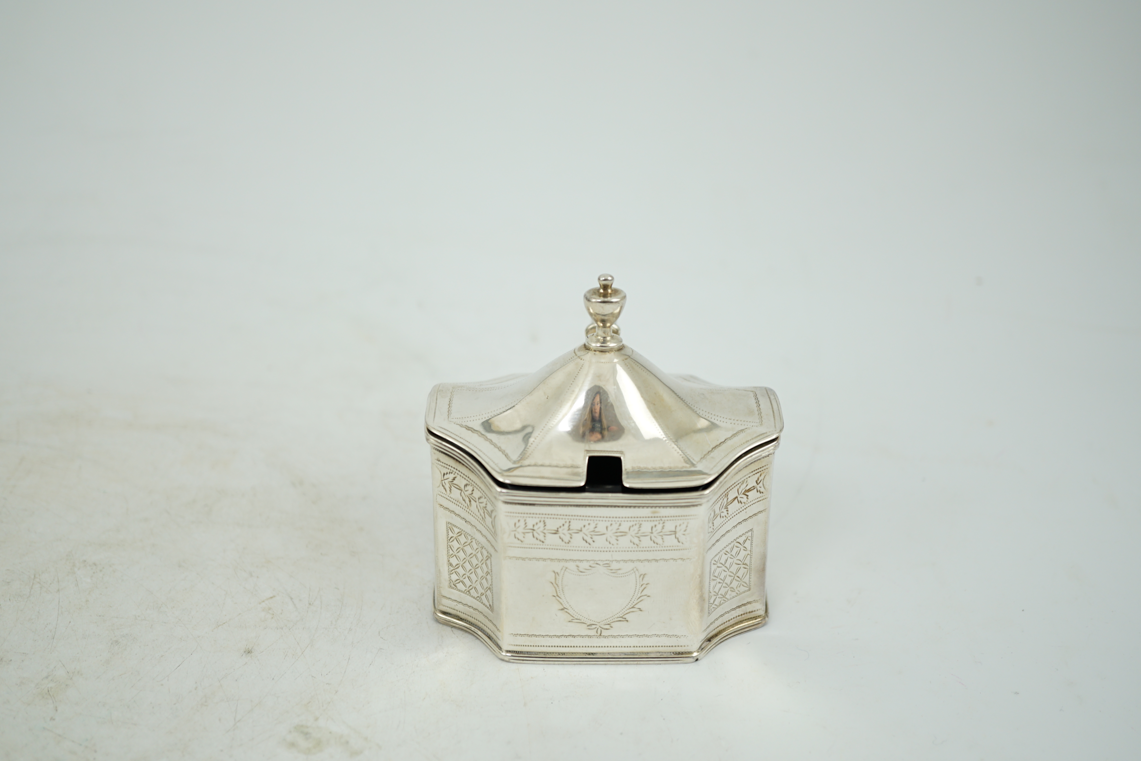 A George III silver mustard pot, with inverted angles and blue glass liner, Alexander Field, London, 1803, height 85mm.